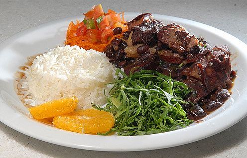 A plate of meat and bean stew with rice.